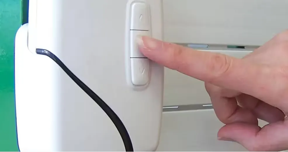 Finger pressing a SmartDrive battery-operated roller shutter switch